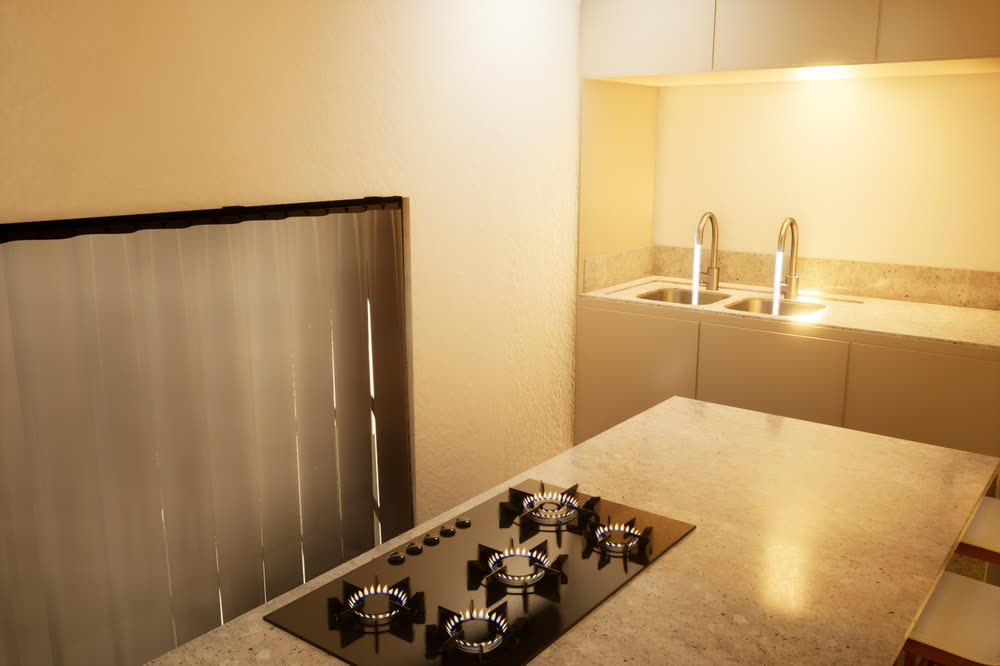 Kitchen island with the gas burners lit, and the sink taps running in the background.